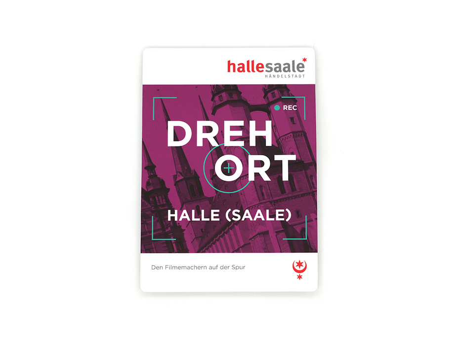 Auf einer magentafarbenen Karte sind die Türme des Halleschen Doms zu sehen, oben „Kulturstadtplan ‚Drehort Halle (Saale)‘“, in fetter weißer Schrift „DREHORT HALLE (SAALE)“ und unten in kleinerer Schrift: „Den Filmproduktionen und ihre Schauplätze auf der Spur“.
