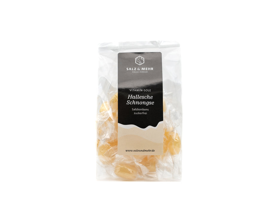 Die Halleschen Schnongse Salzbonbons „Vitamin-Sole“ zuckerfrei der Soole eG präsentieren sich in einem transparenten Beutel mit runden, bernsteinfarbenen Bonbons. Das schwarz-weiße Salz & Mehr Logo ziert die Verpackung. Die veganen Leckereien sind unten auf der Website aufgeführt und enthalten vitaminreiche Zutaten auf Salzbasis.