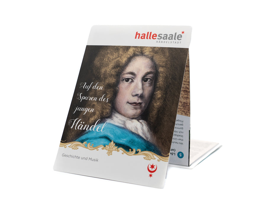 Der gefaltete Kulturstadtplan „Auf den Spuren des jungen Händel“ steht aufrecht und zeigt ein gemaltes Porträt des jungen Händel. Der deutsche Text beleuchtet seine Kindheit und Jugend, Geschichte und Musik. Halle-Saale-Logo.