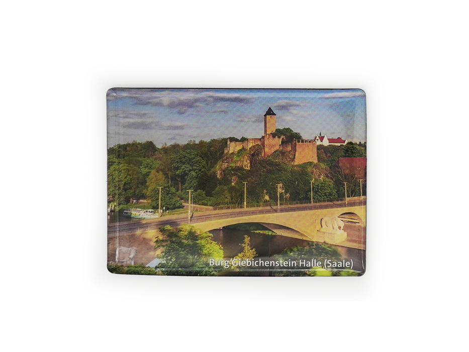 Der Magnet „Burg Giebichenstein“ zeigt ein Foto der Burg mit der Giebichensteinbrücke über den Fluss, umgeben von Bäumen unter leicht bewölktem Himmel. Der Text lautet: „Burg Giebichenstein Halle (Saale)“.