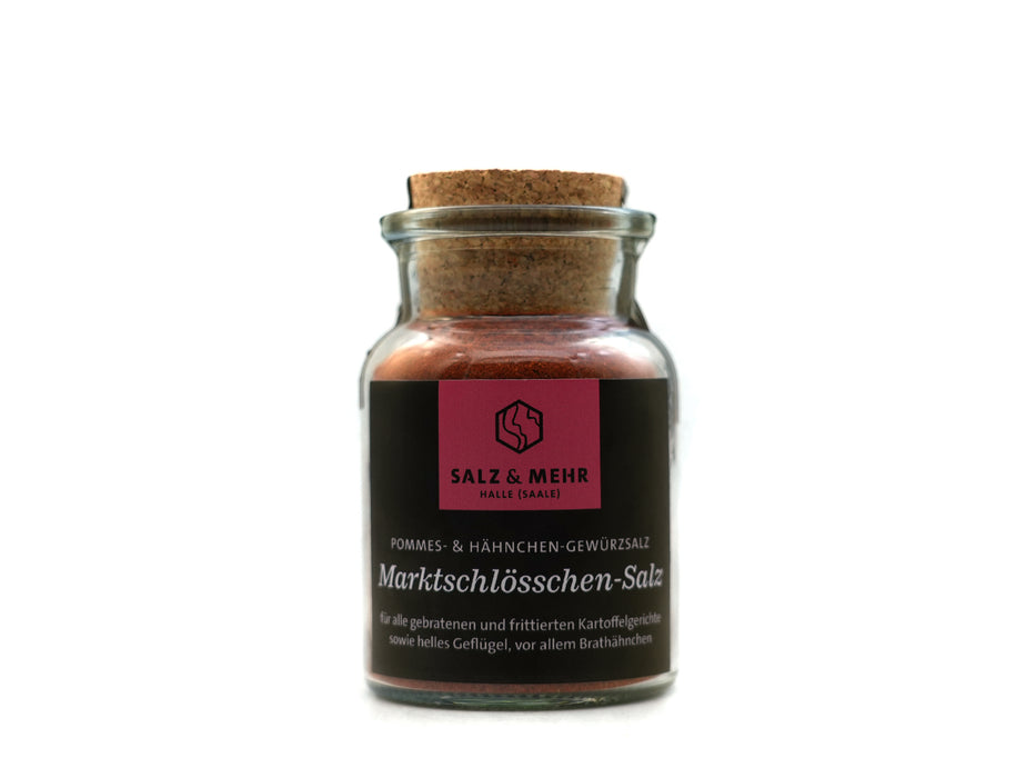 Ein Glasgefäß mit Korkdeckel enthält rötliches Gewürz mit der Aufschrift „SALZ & MEHR“ und „Marktschlösschen-Salz groß mit Salzschaufel“, eine deutsche Gewürzmischung für Pommes, Hähnchen und Bratkartoffeln. Das Etikett ist schwarz und magenta.