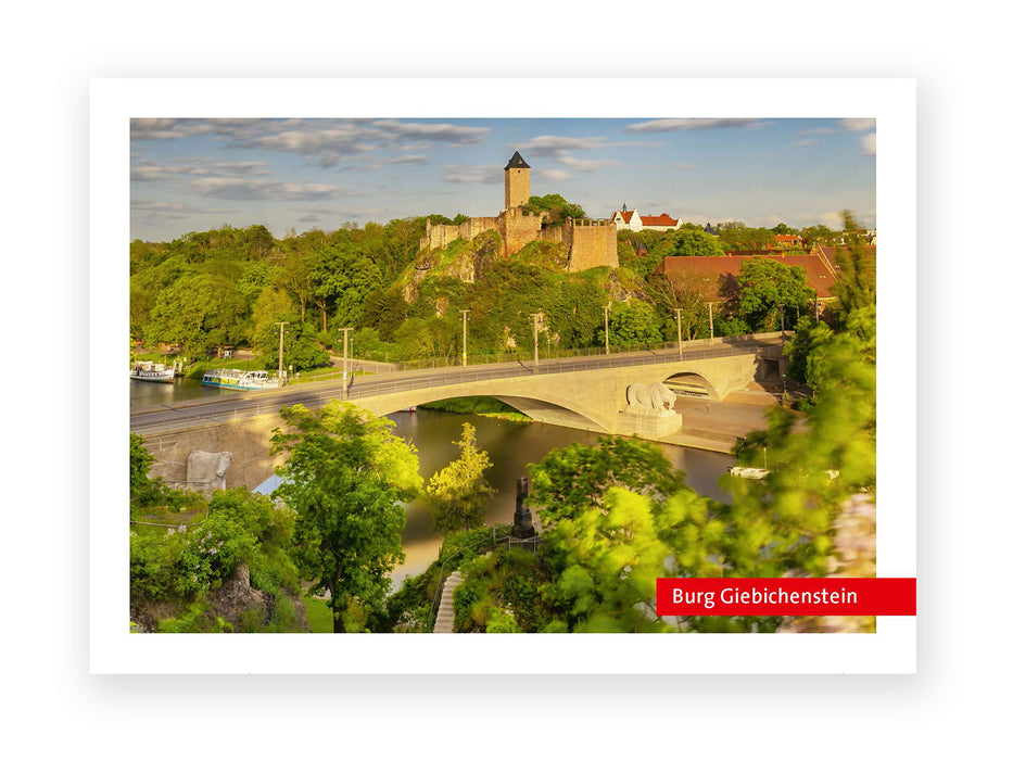 Eine Steinbrücke mit Skulpturen überspannt einen Fluss in Halle (Saale). Auf einem bewaldeten Hügel dahinter erheben sich die mittelalterlichen Mauern und der Turm der Burg Giebichenstein. Leicht bewölkter Himmel. Rotes Etikett: Postkarte "Burg Giebichenstein".
