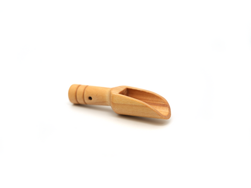 Die Salzschaufel mit Loch von hallesaale* | Shop hat einen kurzen, 5 cm langen Griff mit geschnitzten Ringen für besseren Halt, einen abgewinkelten Ausguss zum einfachen Ausgießen und eine glatte, hellbraune Oberfläche. Nahe der Unterseite befindet sich ein kleines rundes Loch. Sie ist auf weißem Grund platziert.