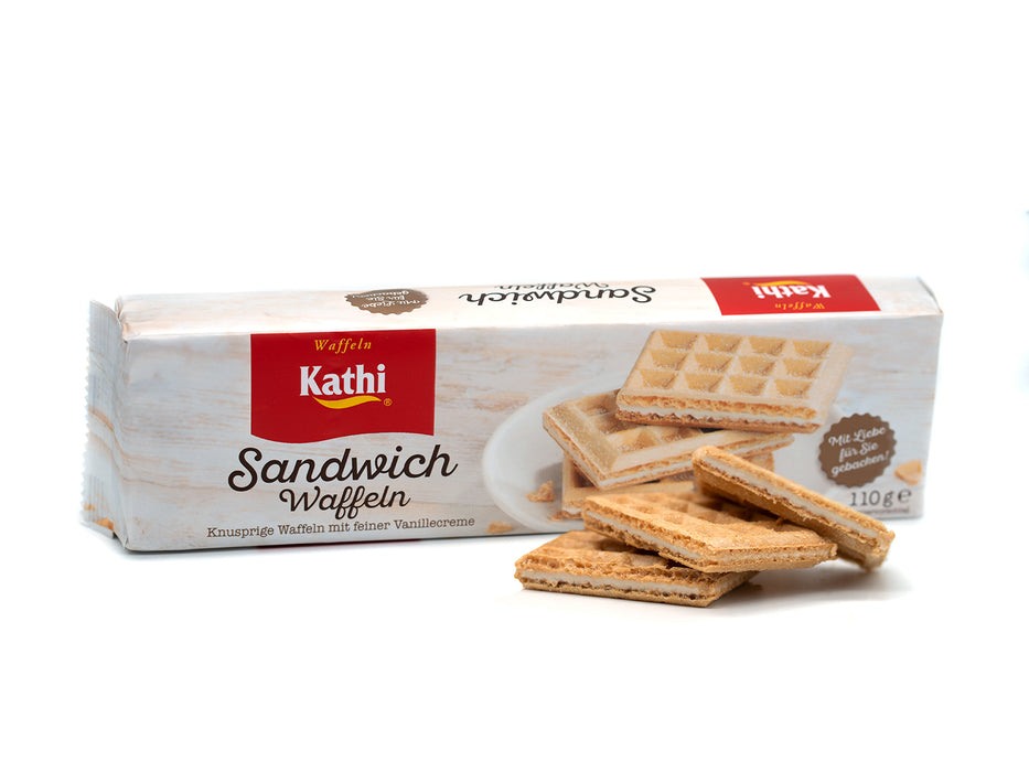 Eine Packung Sandwich-Waffeln ist abgebildet. Vor ihr sind drei rechteckige, mit Vanillecreme gefüllte Waffeln gestapelt. Die Verpackung zeigt ein rotes Etikett, deutschen Text, Abbildungen der Waffeln und das Gewicht: 110 g.