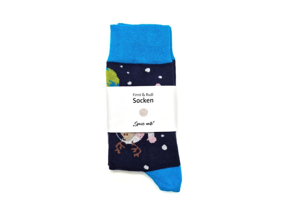 Ein Paar Socken "Finni & Rudi" Space Walk in Marineblau mit hellblauen Zehen- und Bündchen, ordentlich gefaltet. Das Weltraum-Design zeigt Planeten und Sterne, umwickelt mit einem weißen "Finni & Rudi Socken"- und "Space Walk"-Label.
