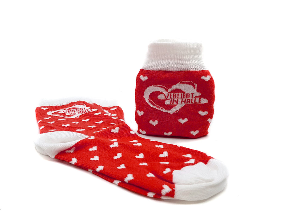 Die Socken „Verliebt in Halle“ bestehen aus kuscheliger Bio-Baumwolle, sind rot mit weißen Herzen, Zehen und Bündchen sowie Schriftzug am Knöchel – gefertigt in Europa. Ideal für gemütliche Tage!.