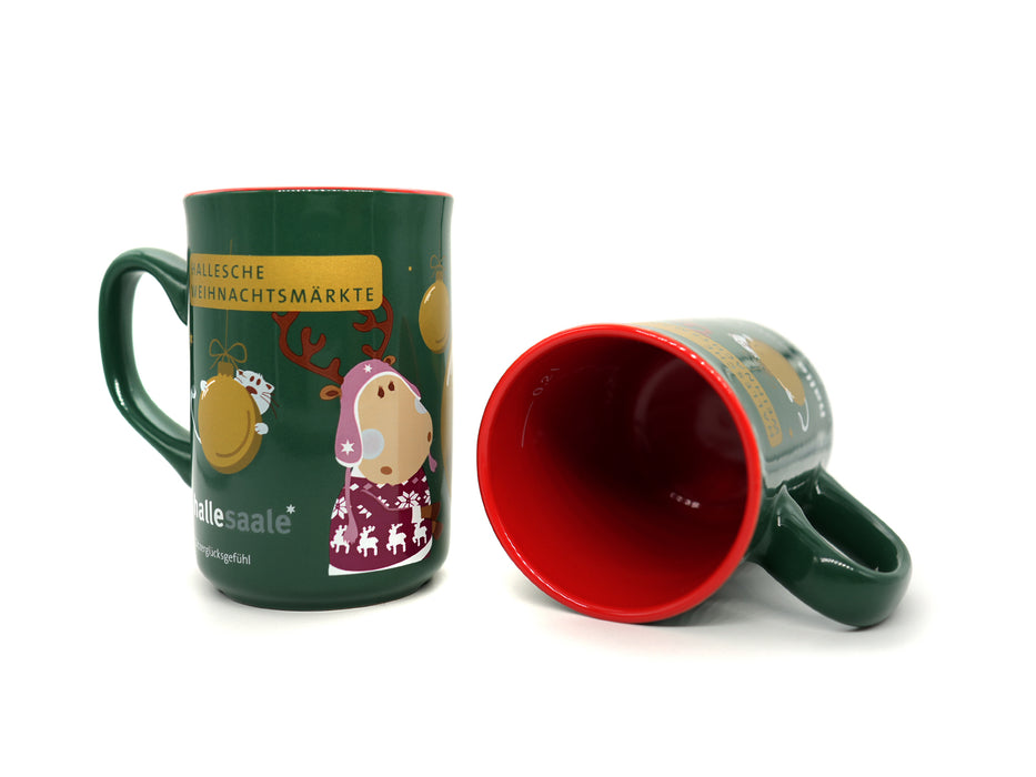 Abgebildet sind zwei grüne Weihnachtstassen „Finni & Rudi“, eine stehend mit einem festlichen Rentier und deutschem Text, die andere liegend. Beide zeigen bezaubernde Weihnachtsmotive aus dem Karton – 48x Tassen-Set „Finni & Rudi“.