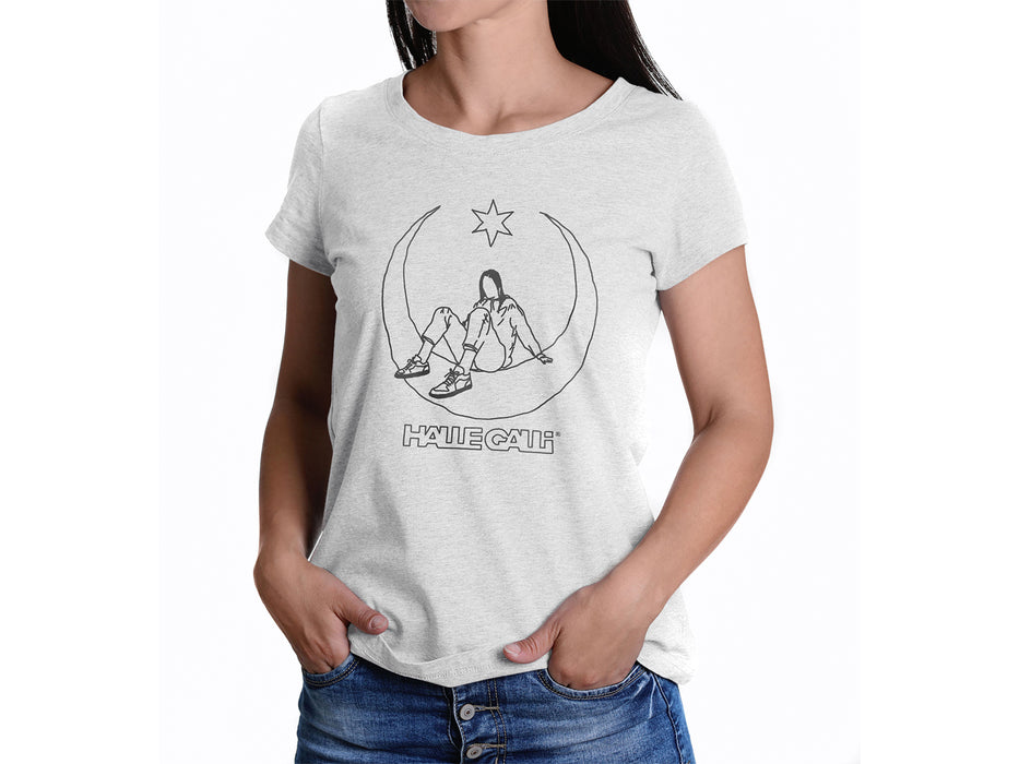 Eine Frau mit langen dunklen Haaren trägt Bluejeans und das T-Shirt „HALLEGALLI® - SCHICKSE“ aus Bio-Baumwolle. Darin ist eine sitzende Figur zwischen Halbmond und Stern in schwarzer Strichzeichnung abgebildet, darunter steht „HALF CALM“. Mittlere Passform, Damen-Style.