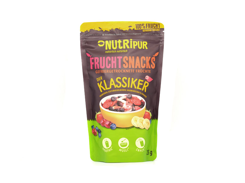 Die Fruchtsnacks „Der Klassiker“ kommen im Standbeutel mit farbenfroher Verpackung und präsentieren gefriergetrocknete Früchte in einer Schale – ideal als Snack oder Müsli-Topping. Der deutsche Text betont die natürlichen, veganen und glutenfreien Eigenschaften.