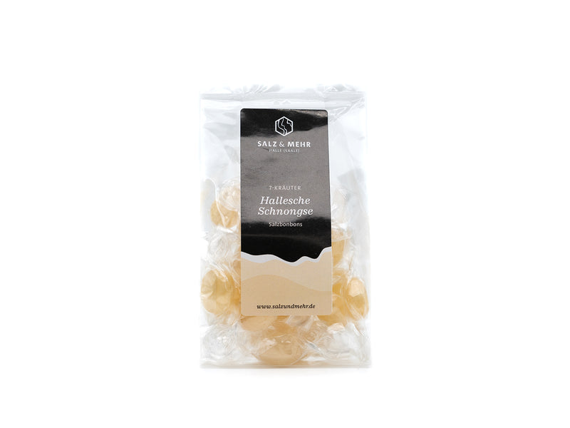Der transparente Beutel der Halleschen Schnongse – Salzbonbons „7-Kräuter“ der Soole eG zeigt ein weißes Etikett mit geometrischem Logo und Text und präsentiert vegane Bonbons, einzeln in transparentem Papier verpackt. Ein Website-Link befindet sich unten. Die Verpackung ist schlicht und übersichtlich.