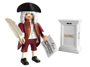 Playmobil-Sonderfigur des Komponisten Georg Friedrich Händel vor weißem Hintergrund. Die Figur trägt eine barocke weiße Perücke, einen Dreispitz-Hut und einen weinroten Mantel mit goldenen Verzierungen. In den Händen hält sie eine große weiße Schreibfeder und ein Notenblatt mit der Aufschrift „Messiah“. Rechts daneben steht ein weißer Sockel mit der goldenen Aufschrift „HAENDEL“.