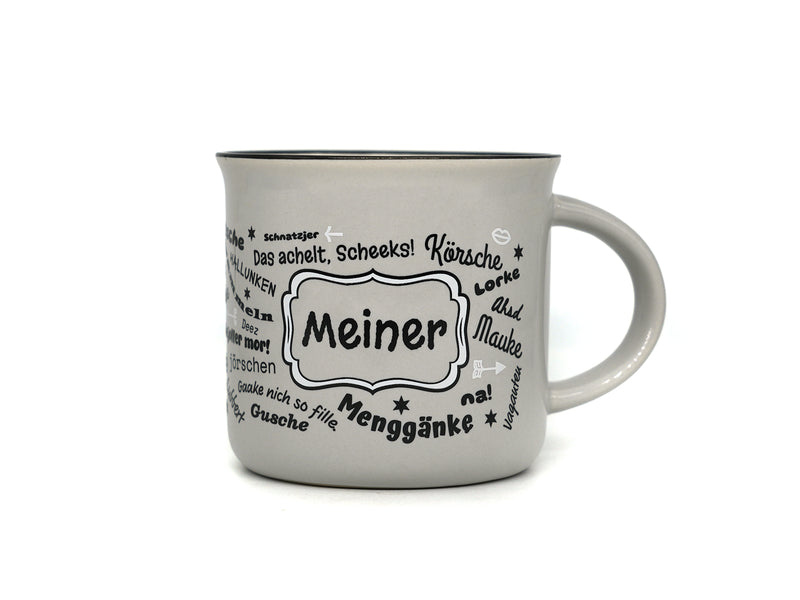 Hellgraue Keramiktasse in klassischer Emaille-Becher-Form mit schwarzem Innenrand. Auf der Frontseite befindet sich der Schriftzug „Meiner“ in einem geschwungenen Rahmen, umgeben von halleschen Mundart-Begriffen wie „Körsche“, „Mauke“ und „Menggänke“.