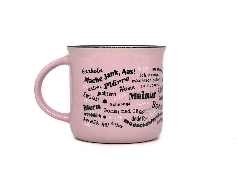 Rosa Keramiktasse in klassischer Emaille-Becher-Form mit schwarzem Innenrand. Auf der Frontseite befindet sich der Schriftzug „Meine“ in einem geschwungenen Rahmen, umgeben von halleschen Mundart-Begriffen wie „Körsche“, „Mauke“ und „Menggänke“.
