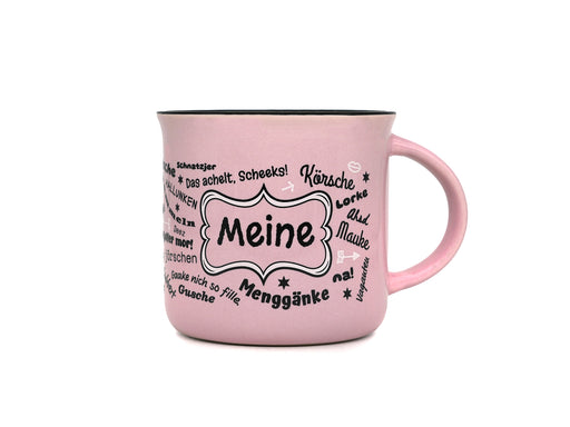 Rosa Keramiktasse in klassischer Emaille-Becher-Form mit schwarzem Innenrand. Auf der Frontseite befindet sich der Schriftzug „Meine“ in einem geschwungenen Rahmen, umgeben von halleschen Mundart-Begriffen wie „Körsche“, „Mauke“ und „Menggänke“.