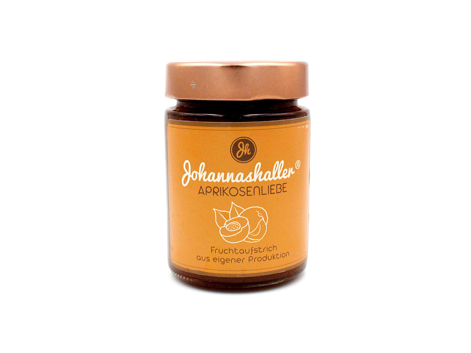 A jar of "Apricot Love" fruit spread from Johannashaller, filled with golden jam made from ripe apricots.